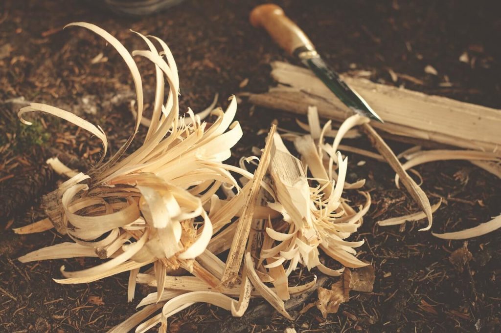 Wood shavings and a woodturning tool, commonly used in woodturning to shape and create cylindrical or rounded objects from wood.